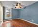Bedroom featuring a wooden ceiling fan, laminate flooring, and window with a street view at 1508 Monument St, Noblesville, IN 46060
