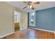 Bedroom featuring a bathroom doorway, wooden ceiling fan, laminate flooring, and window with a street view at 1508 Monument St, Noblesville, IN 46060