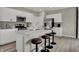 Bright kitchen with white cabinetry, stainless steel appliances, island with bar seating, and hardwood floors at 15334 Swallow Falls Way, Fishers, IN 46037
