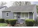 Single-story home with gray siding, trimmed hedges, window box, and a welcoming front entrance at 1643 E Tabor St, Indianapolis, IN 46203