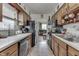 This kitchen features wooden cabinets, a black refrigerator, and a view into the living room at 1643 E Tabor St, Indianapolis, IN 46203