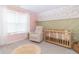 Cozy Bedroom with a wooden crib, comfortable chair, and stylish décor at 192 Lynnette Way, Cumberland, IN 46229