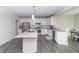 The updated kitchen features white cabinets, a granite countertop island, and stainless appliances at 192 Lynnette Way, Cumberland, IN 46229