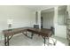 A stylish office featuring an L shaped wooden desk and two comfortable chairs at 192 Lynnette Way, Cumberland, IN 46229