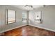 Simple bedroom with wood floors, ceiling fan, and three windows at 21 N Bosart Ave, Indianapolis, IN 46201