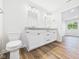 Bright bathroom with double sinks, white cabinets, and a view into the bedroom at 2327 Mimosa Ln, Anderson, IN 46011
