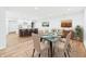 Dining room with a glass table, seating for six, open to the kitchen and wood floors at 2327 Mimosa Ln, Anderson, IN 46011