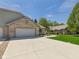 Brick home with a three car garage and a concrete driveway surrounded by green lawns at 2327 Mimosa Ln, Anderson, IN 46011