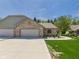 Brick home with a three car garage, concrete driveway, and covered walkway on a lush lawn at 2327 Mimosa Ln, Anderson, IN 46011