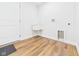 Bright laundry room with a utility sink, washer/dryer hookups, and wood-look flooring at 2327 Mimosa Ln, Anderson, IN 46011