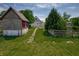 A fenced yard features green grass, mature trees, and a garden shed at 2402 N B St, Elwood, IN 46036