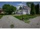 Exterior view of a home showing the garage, a gravel driveway, and a well-maintained lawn at 2402 N B St, Elwood, IN 46036