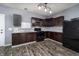 Kitchen with dark cabinets, stainless appliances, and modern flooring at 2402 N B St, Elwood, IN 46036