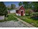 View of a small shed with peeling paint in a backyard with a gravel driveway at 2402 N B St, Elwood, IN 46036