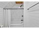 Bright white bathroom with tiled shower and tub features black hardware and natural light at 2450 S Us 421, Zionsville, IN 46077