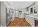 Bright kitchen boasts stainless steel appliances, white cabinets, and stylish wood floors at 2450 S Us 421, Zionsville, IN 46077
