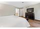 Hardwood floors in the main bedroom leading to the ensuite bathroom, featuring a sliding barn door and a TV at 2450 S Us 421, Zionsville, IN 46077