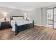 Main bedroom with hardwood floors and a view of the ensuite bathroom featuring a sliding barn door at 2450 S Us 421, Zionsville, IN 46077