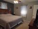 Cozy bedroom features a bed, windows with floral curtains, and side tables at 2630 Wedgewood Dr, Columbus, IN 47203