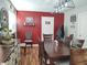 Spacious dining room with laminate flooring, red accent wall, and dark wood table at 2630 Wedgewood Dr, Columbus, IN 47203