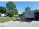 Spacious driveway leading to a two-car garage, complemented by a well-kept lawn and mature trees at 2630 Wedgewood Dr, Columbus, IN 47203