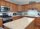 Well-lit kitchen featuring stainless steel appliances, granite countertops, and wooden cabinetry at 2630 Wedgewood Dr, Columbus, IN 47203