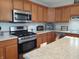 Well-lit kitchen featuring stainless steel appliances, granite countertops, and wooden cabinetry at 2630 Wedgewood Dr, Columbus, IN 47203