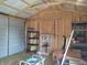 A shed interior with exposed framing, an open garage door and various storage racks at 2630 Wedgewood Dr, Columbus, IN 47203
