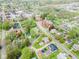 An aerial view of a home in a residential area with mature trees, a detached garage, and a neatly mowed lawn at 300 E 2Nd St, Sheridan, IN 46069