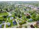 Aerial view of property showcasing neighborhood, mature trees, manicured lawn, and nearby downtown businesses at 300 E 2Nd St, Sheridan, IN 46069