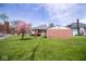 Expansive backyard featuring a mature tree, detached garage and lush green lawn at 300 E 2Nd St, Sheridan, IN 46069
