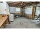 Unfinished basement space with exposed beams and a utility sink awaits customization and finishing touches at 300 E 2Nd St, Sheridan, IN 46069