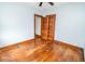 Empty room features worn hardwood floors, neutral walls, ceiling fan, and closet at 300 E 2Nd St, Sheridan, IN 46069