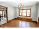 A formal dining room features a vintage light fixture, hardwood floors, and large windows at 300 E 2Nd St, Sheridan, IN 46069