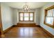 A spacious dining room has a vintage light fixture, hardwood floors, and abundant natural light at 300 E 2Nd St, Sheridan, IN 46069
