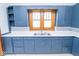 Classic kitchen with natural light over the sink and blue cabinetry with white countertops at 300 E 2Nd St, Sheridan, IN 46069