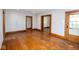 A bright living room features original wood floors and trim with neutral paint, awaiting your personal touch at 300 E 2Nd St, Sheridan, IN 46069