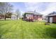 Exterior of home with a deck attached to a back door and a large lawn leading to a detached garage at 300 E 2Nd St, Sheridan, IN 46069