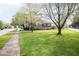 View of the home's side exterior with a large manicured yard and a sidewalk going down the side of the property at 300 E 2Nd St, Sheridan, IN 46069