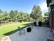 A well-maintained backyard features a grassy lawn, a concrete patio, and mature trees providing ample shade at 3085 Oakmont Dr, Lapel, IN 46051