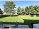 Picturesque backyard with lush green grass, a wooden fence, and mature trees at 3085 Oakmont Dr, Lapel, IN 46051