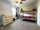 Spacious bedroom with a bunk bed, ceiling fan, large window, and a bright, neutral color scheme at 3085 Oakmont Dr, Lapel, IN 46051