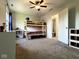 Neutral bedroom with ceiling fan, bunk bed, and a view to the ensuite bathroom at 3085 Oakmont Dr, Lapel, IN 46051