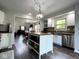 Bright kitchen features a center island, stainless steel sink, and hardwood floors at 3085 Oakmont Dr, Lapel, IN 46051