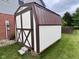 New outdoor shed with white siding, brown trim, and a metal roof is perfect for storing all your lawn care needs at 3085 Oakmont Dr, Lapel, IN 46051