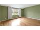The bedroom has hardwood floors, neutral walls, and a large window for plenty of natural light at 32 W Michigan St, Greenfield, IN 46140