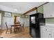 Cozy dining area featuring a wooden table and chairs next to the kitchen and refrigerator at 32 W Michigan St, Greenfield, IN 46140