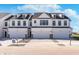 Modern townhome with a white exterior, dark trim, and individual garages with ample parking in the driveway at 3305 Noriker Ln, Zionsville, IN 46077