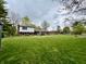 Large backyard with lush green lawn, mature trees, and brick home at 337 Leaning Tree Rd, Greenwood, IN 46142