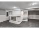 Finished basement area featuring built-in shelving, painted paneling, and stairs to the upper level at 3549 N Sherman Dr, Indianapolis, IN 46218